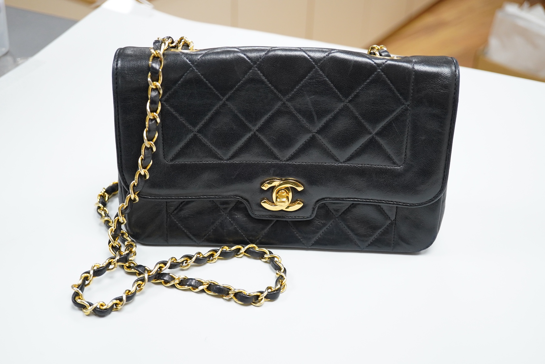 A late 1980’s Chanel black leather Diana shoulder bag with original dust cover and bag, Chanel authenticity card numbered 1944645, interior date code rubbed, 23cm wide, Provenance: Purchased by the vendor, 26 Old Bond St